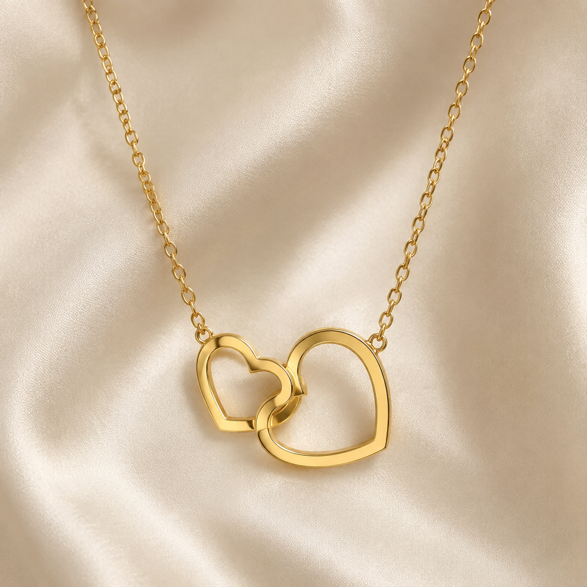 Collar Nara dorado de dos corazones entrelazados sobre seda marfil