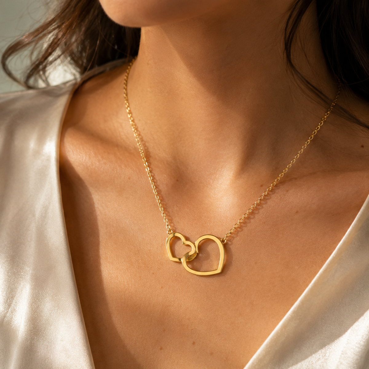 Collar Nara de dos corazones dorados puesto sobre el escote